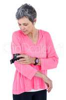 Woman adjusting armband while listening music