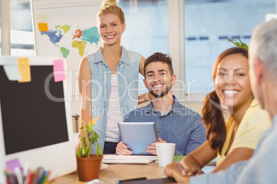 Smiling business people using digital PC