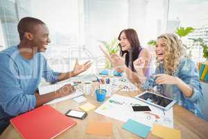 Business people laughing while working at desk