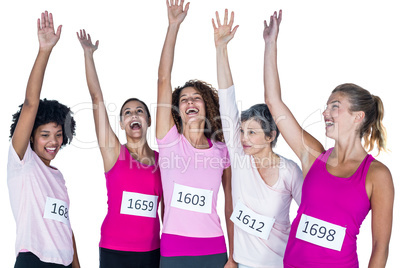 Cheerful female athletes with arms raised