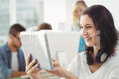 Smiling woman with headphones using digital tablet