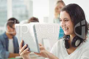Smiling woman with headphones using digital tablet