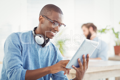 Smiling man with headphones while using digital tablet