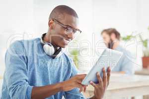 Smiling man with headphones while using digital tablet