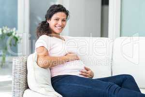 Portrait of happy woman sitting on lounge furniture