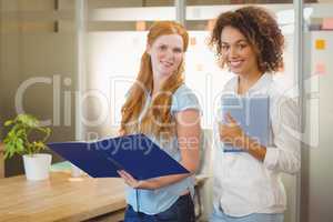 Businesswomen holding document and digital tablet