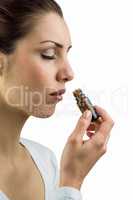 Close-up of woman smelling medicine bottle