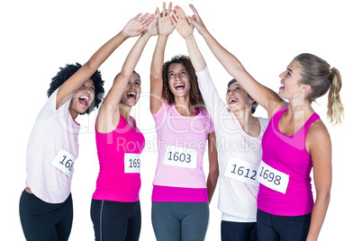 Smiling athletes putting their hands together with arms raised