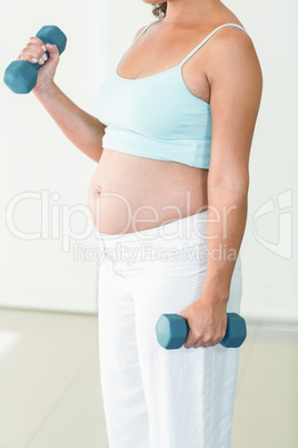 Pregnant woman exercising with dumbbells