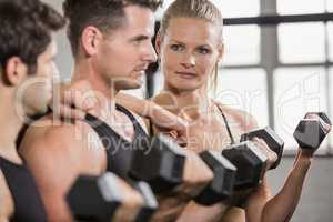 Focused people lifting dumbbell