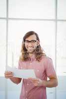 Portrait of happy hipster holding paper