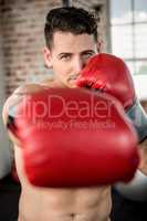 Portrait of a muscular man wearing boxing gloves