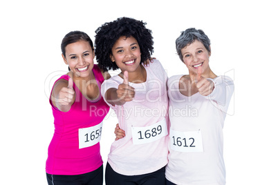 Portrait of smiling female athletes with thumbs up