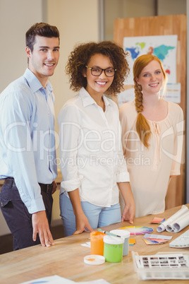 Confident business people standing by desk