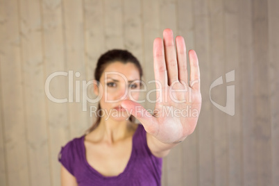 Portrait of serious woman showing stop sign