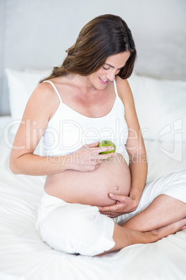Happy woman with Granny Smith on belly