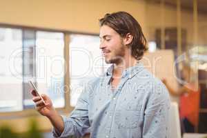 Confident businessman texting on phone