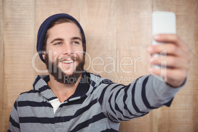 Happy hipster with hooded shirt taking selfie