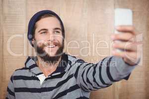 Happy hipster with hooded shirt taking selfie