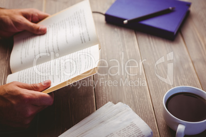 Person holding book at desk