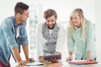 Smiling business professionals using digital tablet