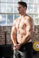 Muscular serious man posing in crossfit gym
