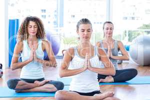 Focused women in lotus pose with hands joined