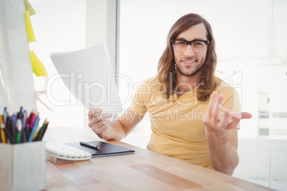 Portrait of happy hipster gesturing in office