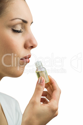 Close-up of female patient with eyes closed while smelling bottl