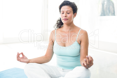 Pregnant woman meditating in lotus position