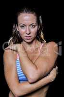 Portrait of female bodybuilder hugging herself