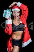 Portrait of cheerful athlete holding Christmas gift