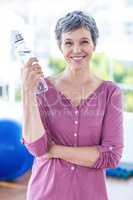Portrait of cheerful mature woman holding water bottle