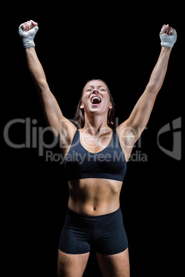 Cheerful winning athlete against black background