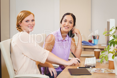 Businesswomen siting by desk