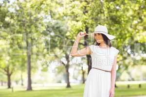 Confident young woman holding sun hat