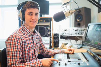 Portrait of radio host using sound mixer