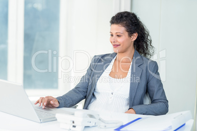 Pregnant businesswoman working on computer