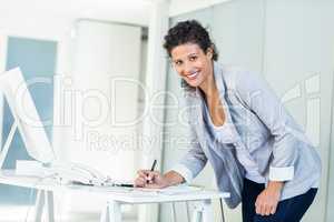 Portrait of beautiful businesswoman writing