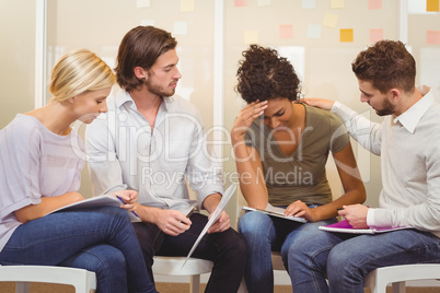 Colleagues supporting tensed businesswoman