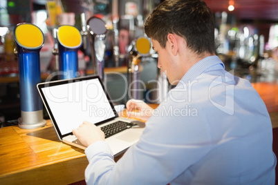 Man working on laptop at bar counter