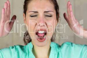 Close-up of screaming woman gesturing with eyes closed