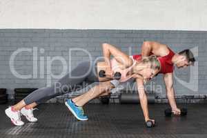 Fit couple doing dumbbell rows