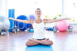 Woman in lotus posture with arms outstretched