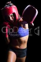 Female boxer with gloves and headgear punching