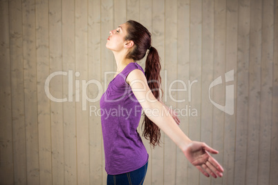 Side view of woman with arms outstretched and eyes closed