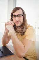 Confident hipster at desk in office