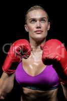 Confident female boxer with gloves