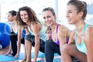 Portrait of women doing high lunge pose in fitness studio