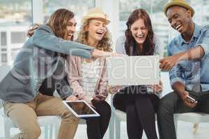 Business people laughing while pointing at laptop